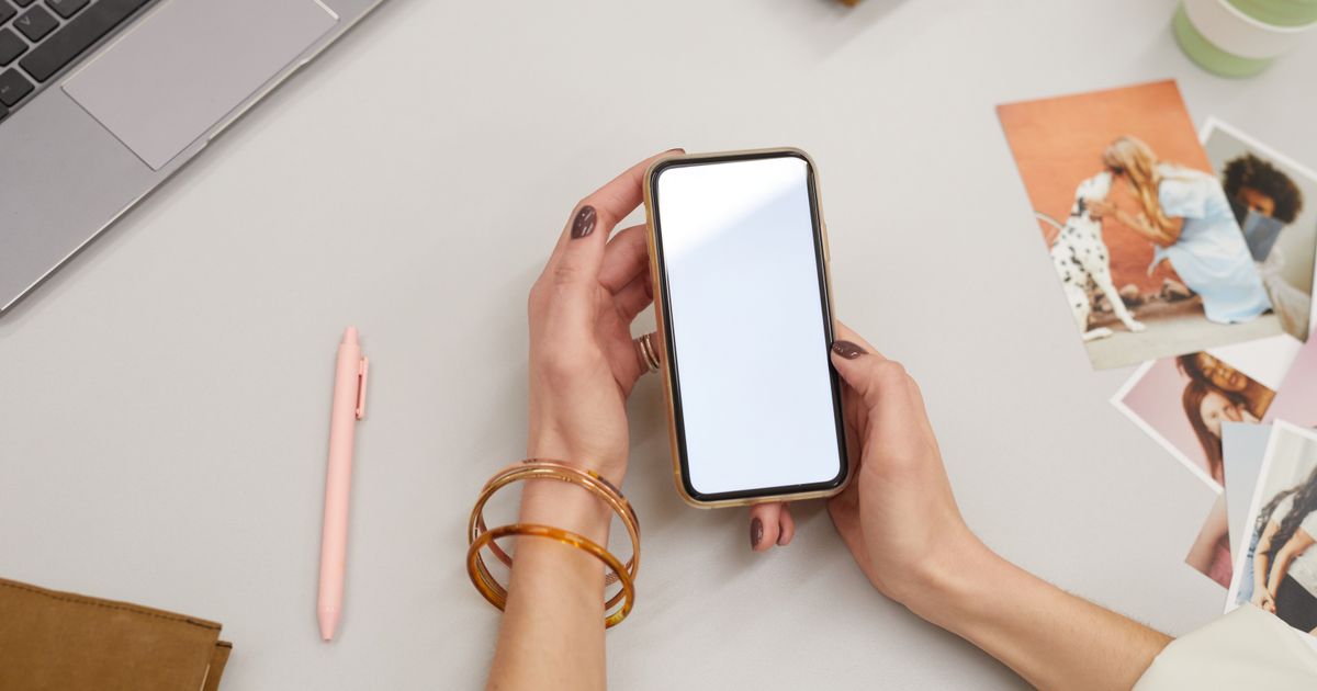 Manos sosteniendo un celular para cobrar con Mercado Pago desde el teléfono