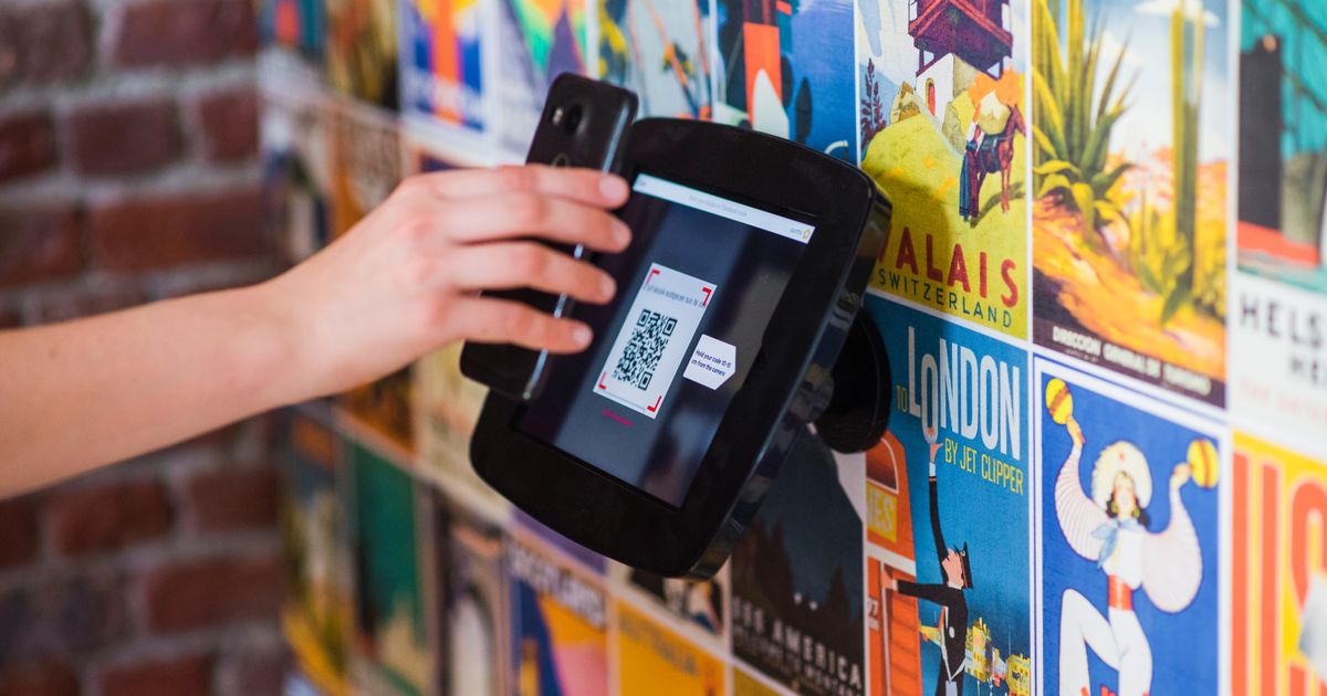 Persona escaneando un código QR con el celular para pagar
