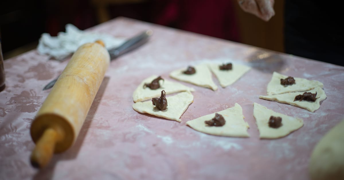 Masa estirada con relleno de chocolate sobre la mesa de la cocina, antes de calcular el precio de un producto alimenticio