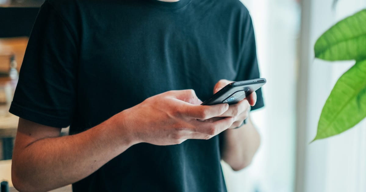 Emprendedor con el celular en la mano preparando una publicación para vender por Instagram