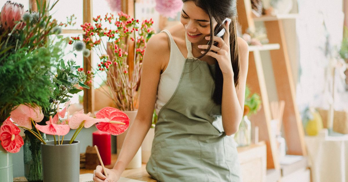 Emprendedora usando el celular para responder mensajes y vender por WhatsApp