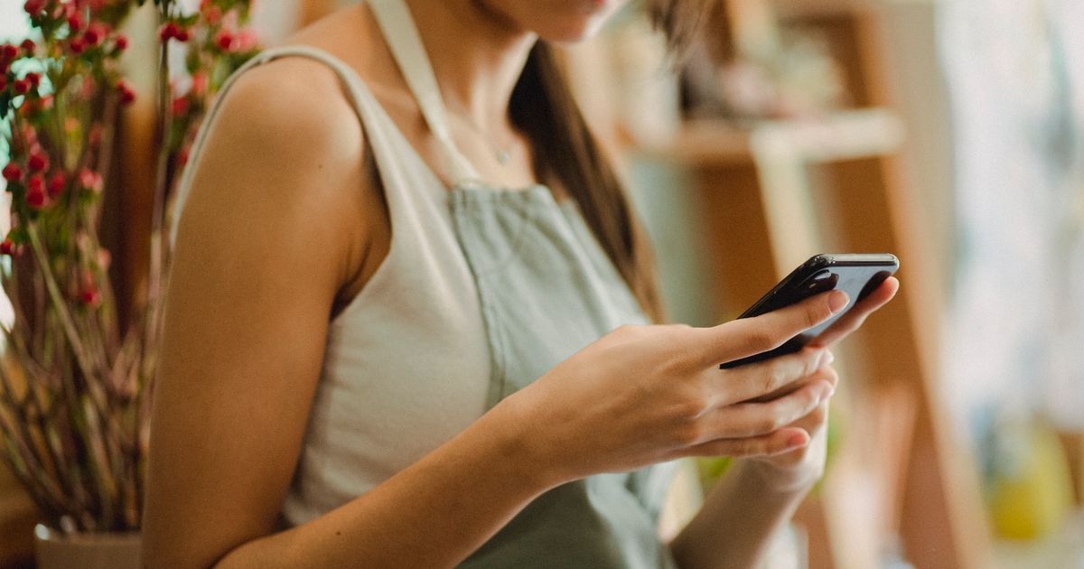 Emprendedora usando el celular para vender por Facebook o Instagram en su negocio